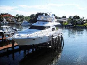 Large white yacht sits above the water on vintage IMM Quality Boat Lift