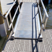 Metal gangway creates walkway to floating boat dock
